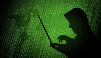 Dark web threats represented by hooded hacker silhouette typing on laptop with green code background